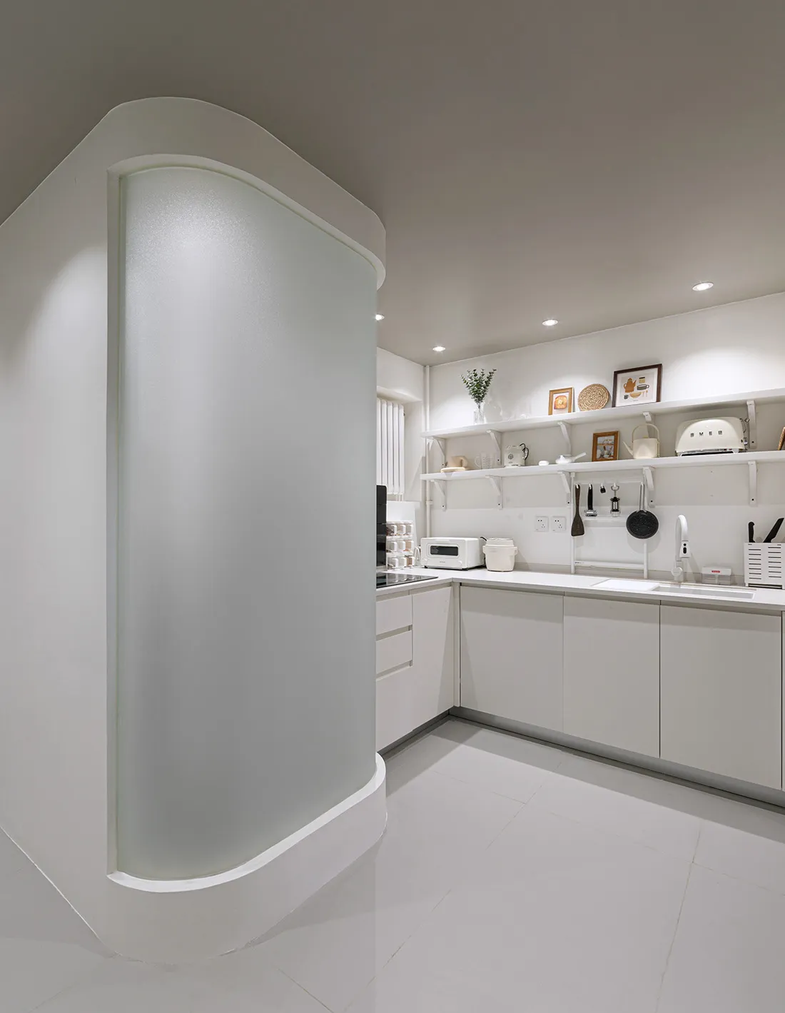 A minimalist kitchen with white textured marble counter and white cabinets.