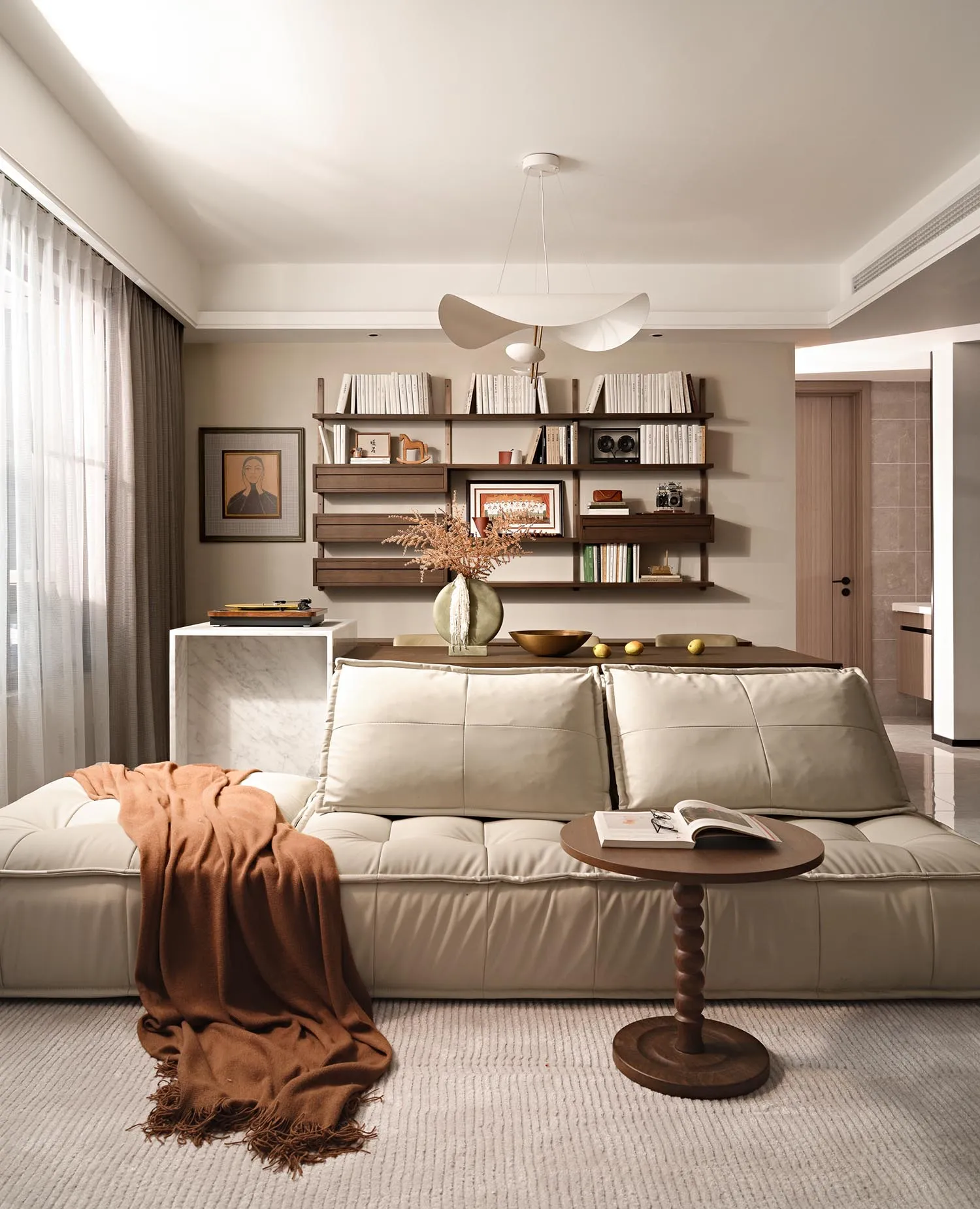 Minimalist living room with a white sofa, wooden coffee table, and eclectic rustic decor.