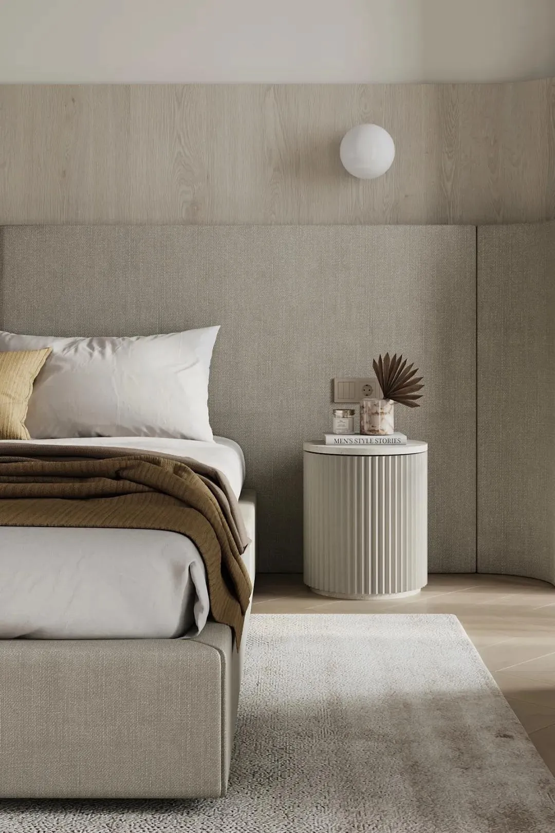 A modern minimalist bedroom with a fabric bed, wooden headboard, and a sleek, rounded bedside table with a marble top.