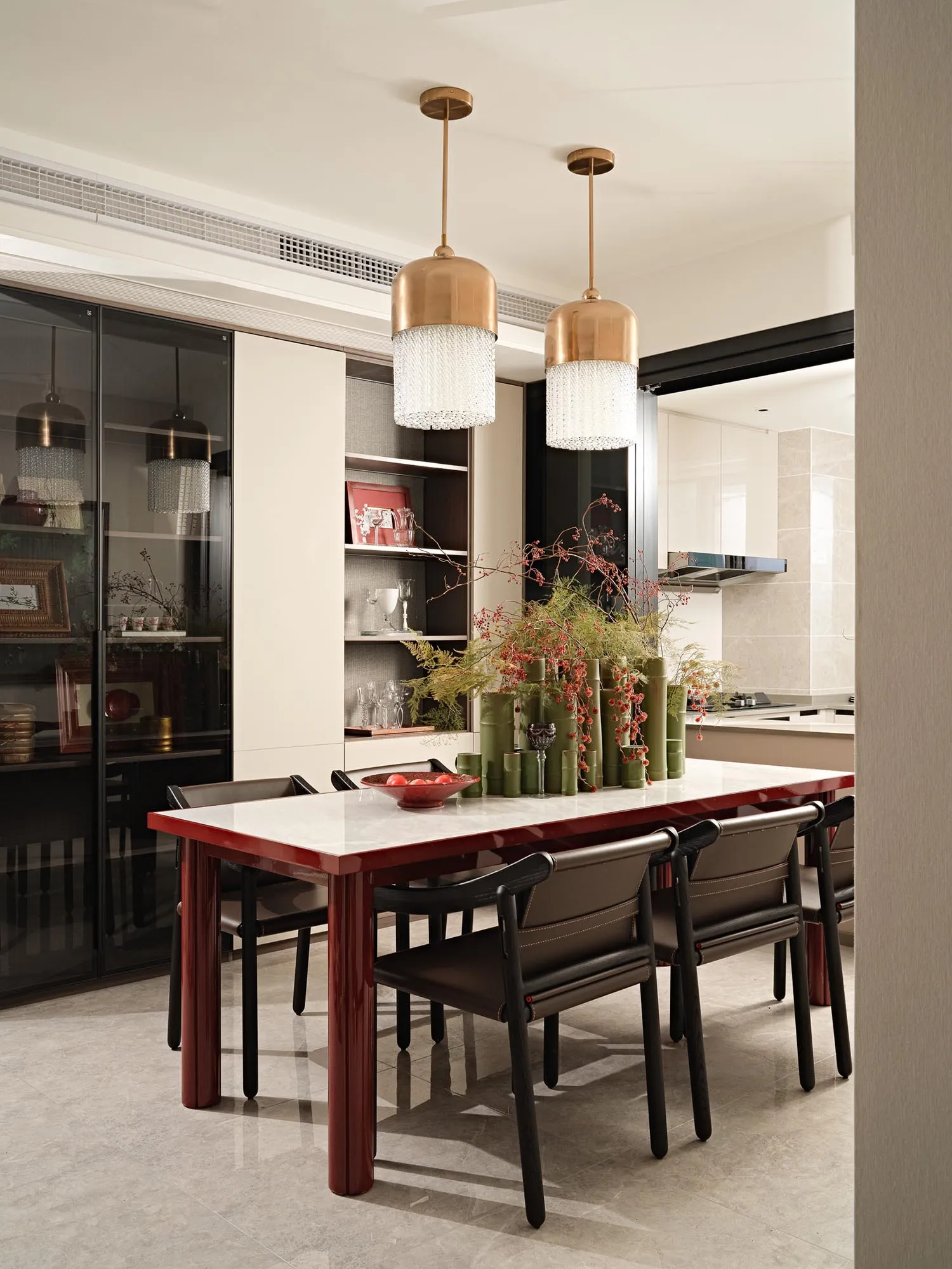 Modern dining room with marble table, wooden chairs, glass decorations, and metal accents.