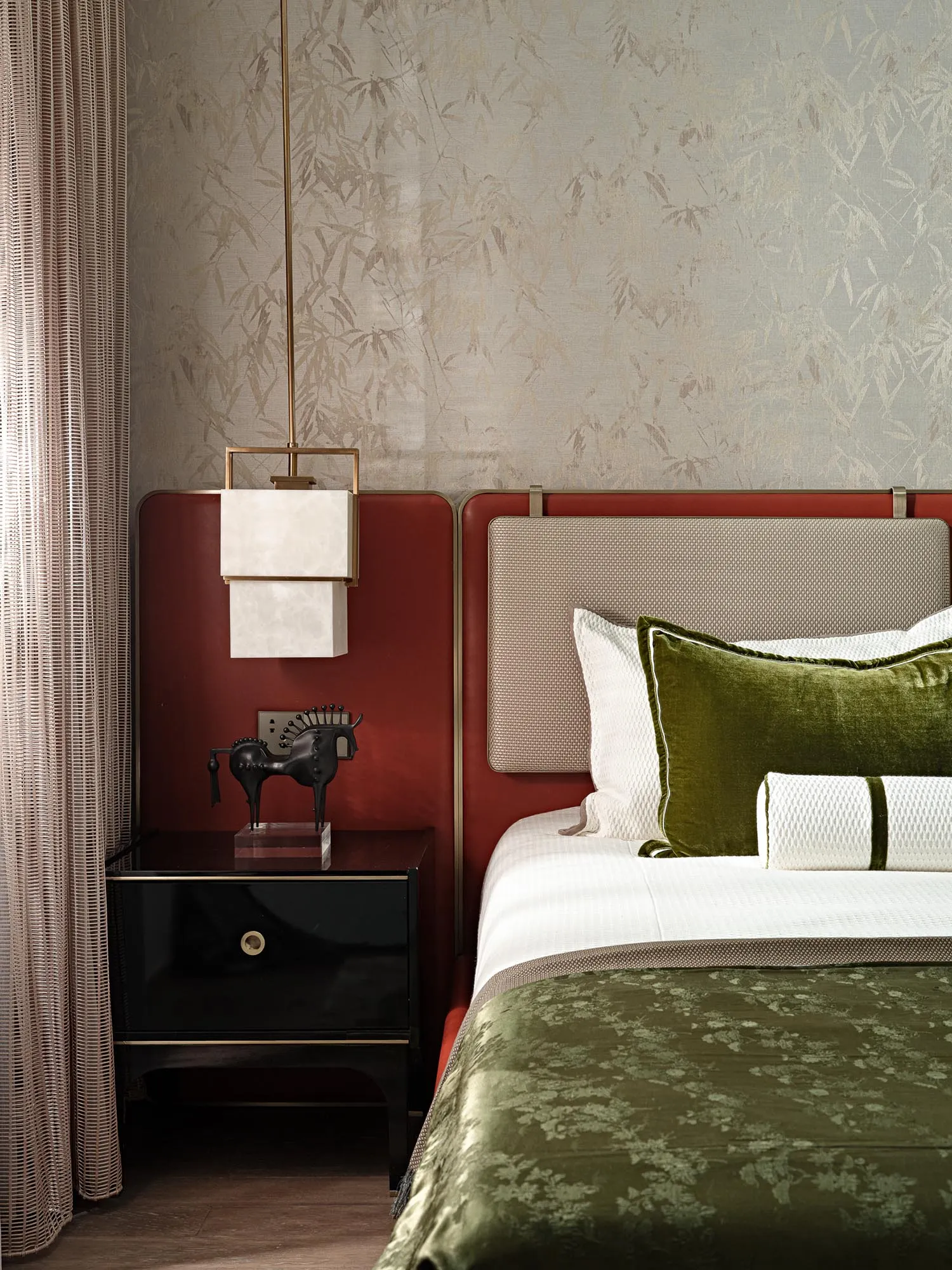 Modern minimalist bedroom with green velvet bedding, white walls, and red accents