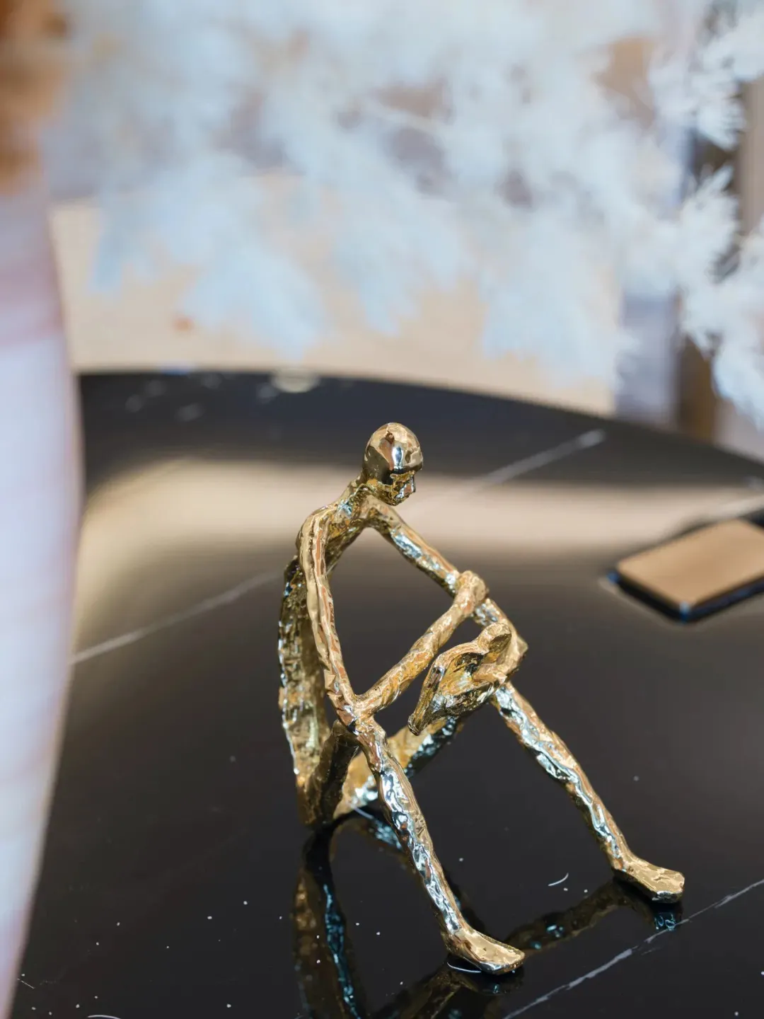 A minimalist figurine crafted from brass material.