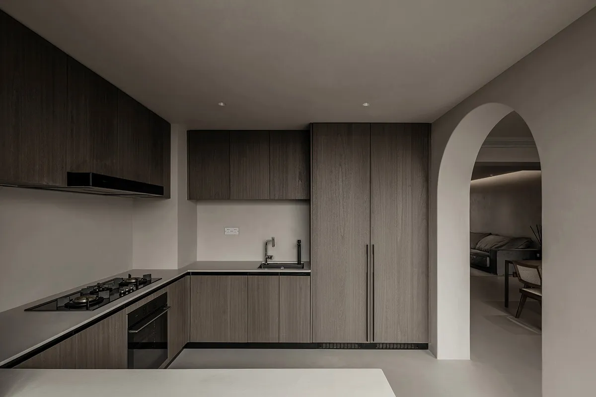Modern minimalist kitchen with dark wood cabinets and a white countertop.