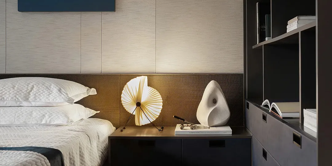 Modern minimalist bedroom with metal headboard and wooden accents.