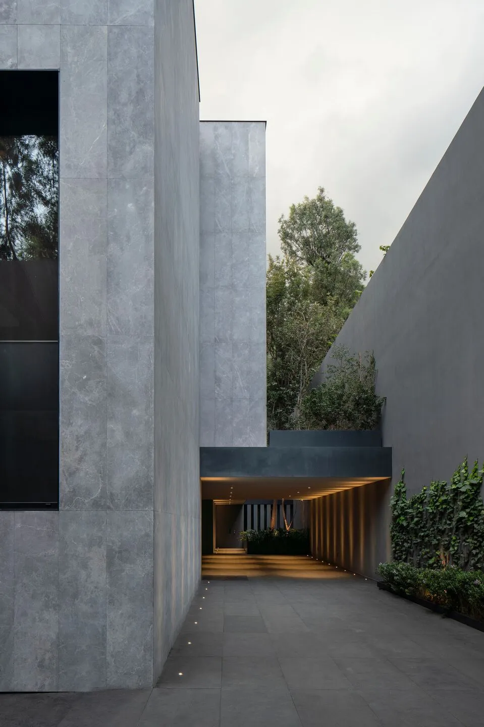 Modern building with concrete exterior and greenery.