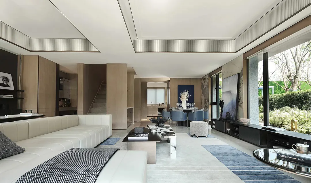 Modern living room with a white sectional sofa and black and white coffee table.