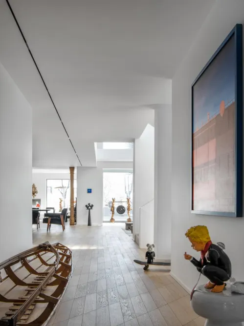 A modern living room featuring a white color scheme, wooden floors, and glass elements.
