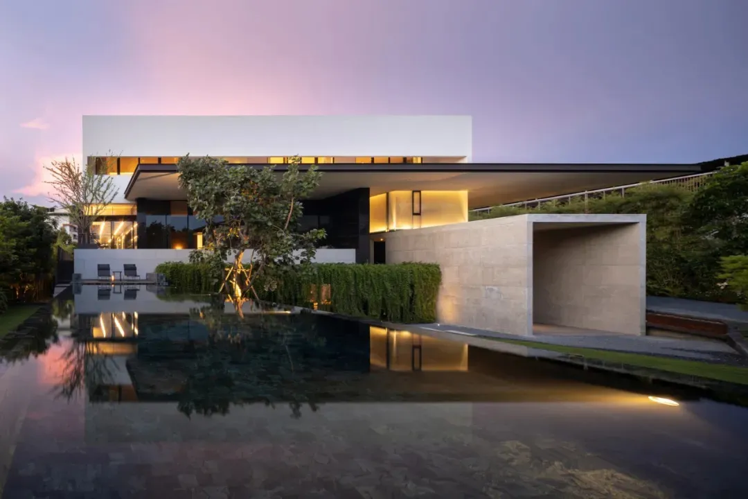 A modern residential exterior with glass, concrete, and metal materials
