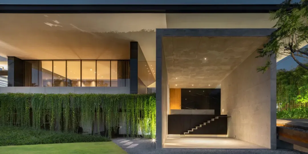 An elegant residential interior featuring a mix of concrete and glass materials.