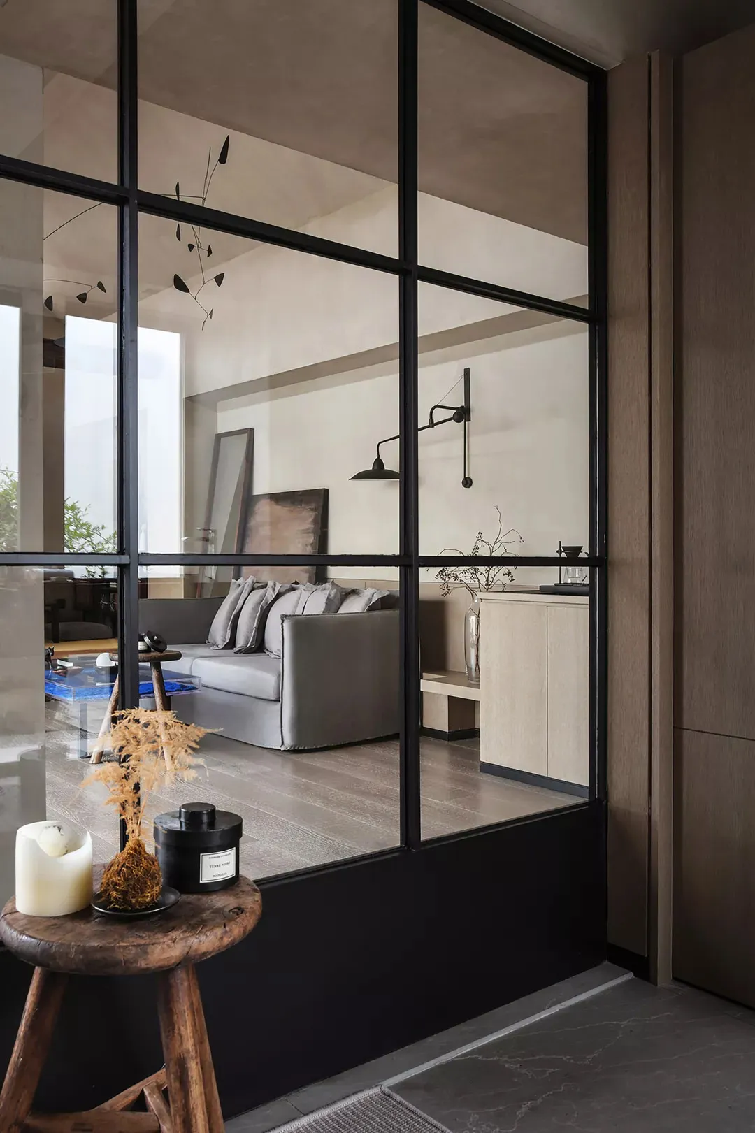 A modern living room with glass walls, carpet flooring, concrete walls, and minimalist furniture.