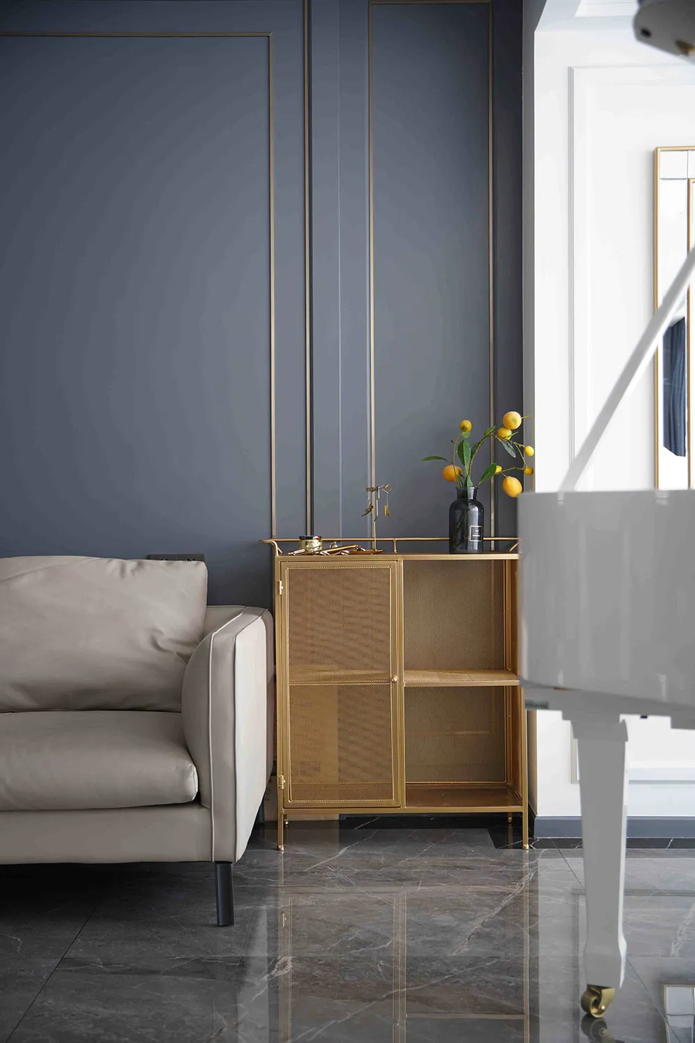 A modern living room featuring minimalist decor with metallic and glass elements.