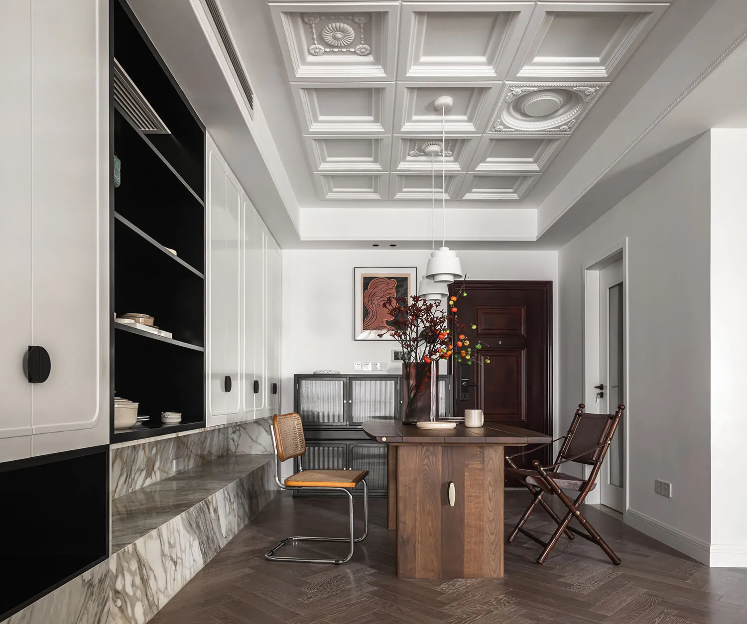 A modern minimalist residential kitchen with a dark wood island and marble countertops.