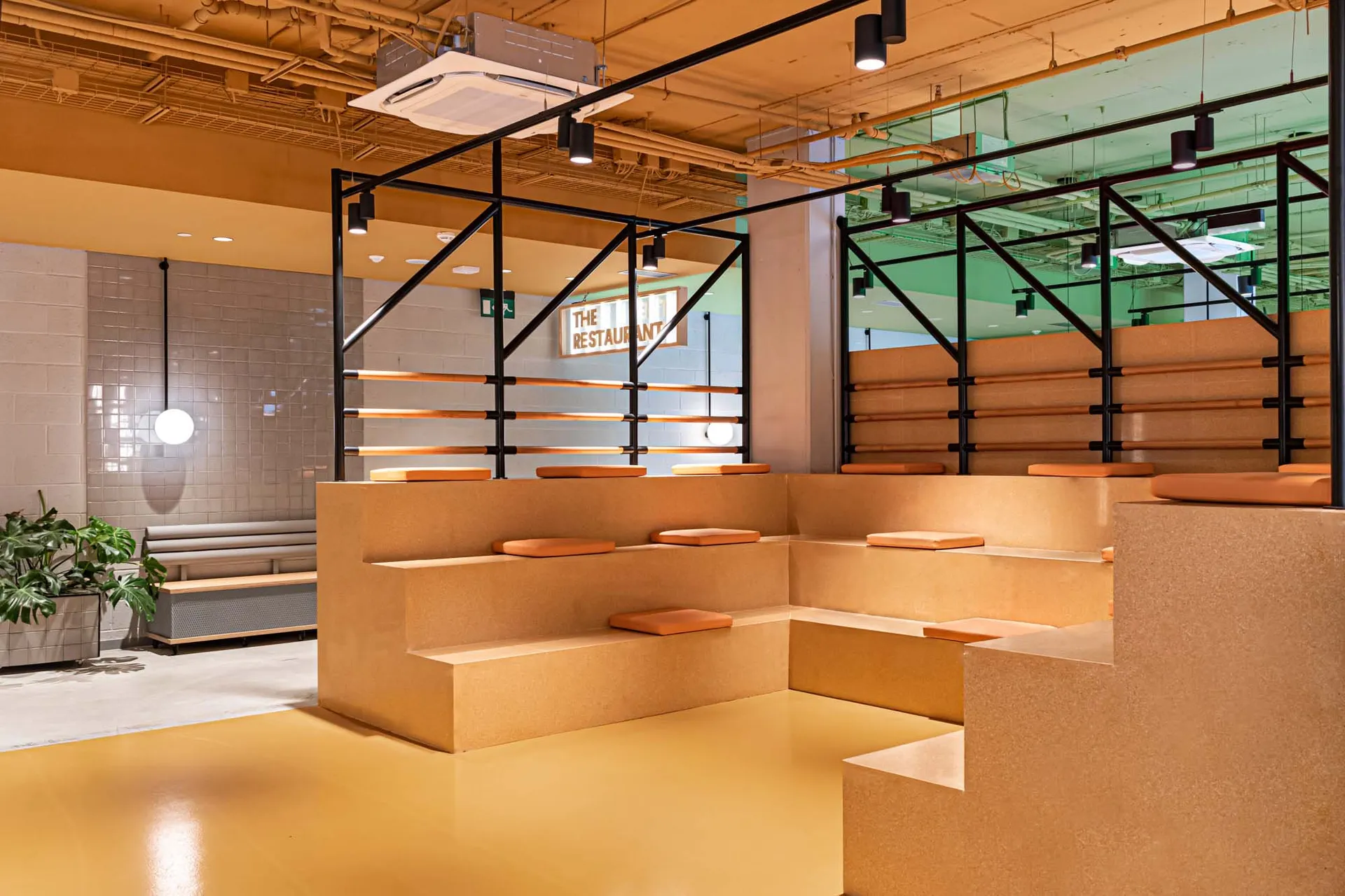 Modern industrial restaurant seating area with concrete, brick, and wooden elements