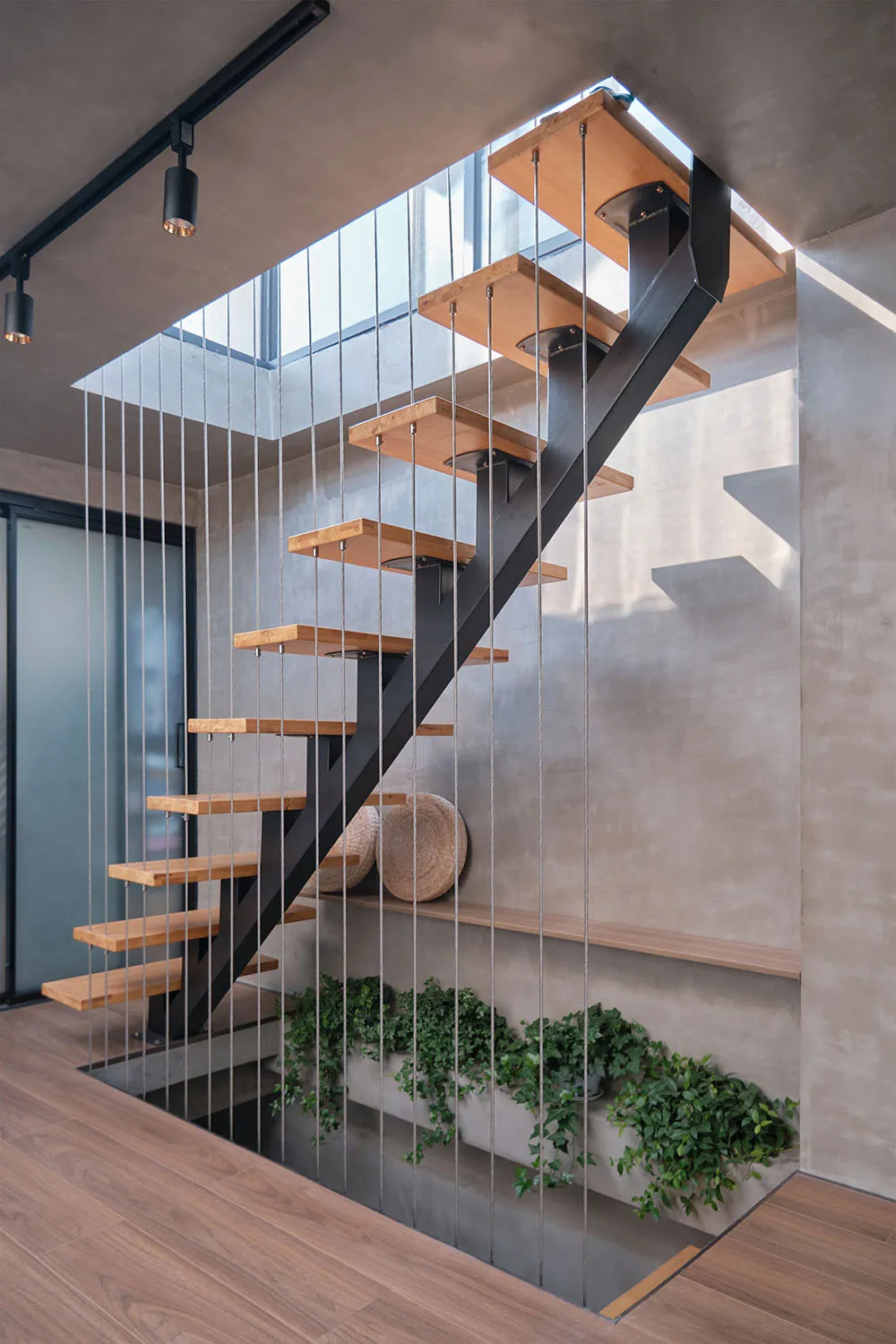 現代室內樓梯,搭配金屬欄杆扶手與木質踏板及踢面。