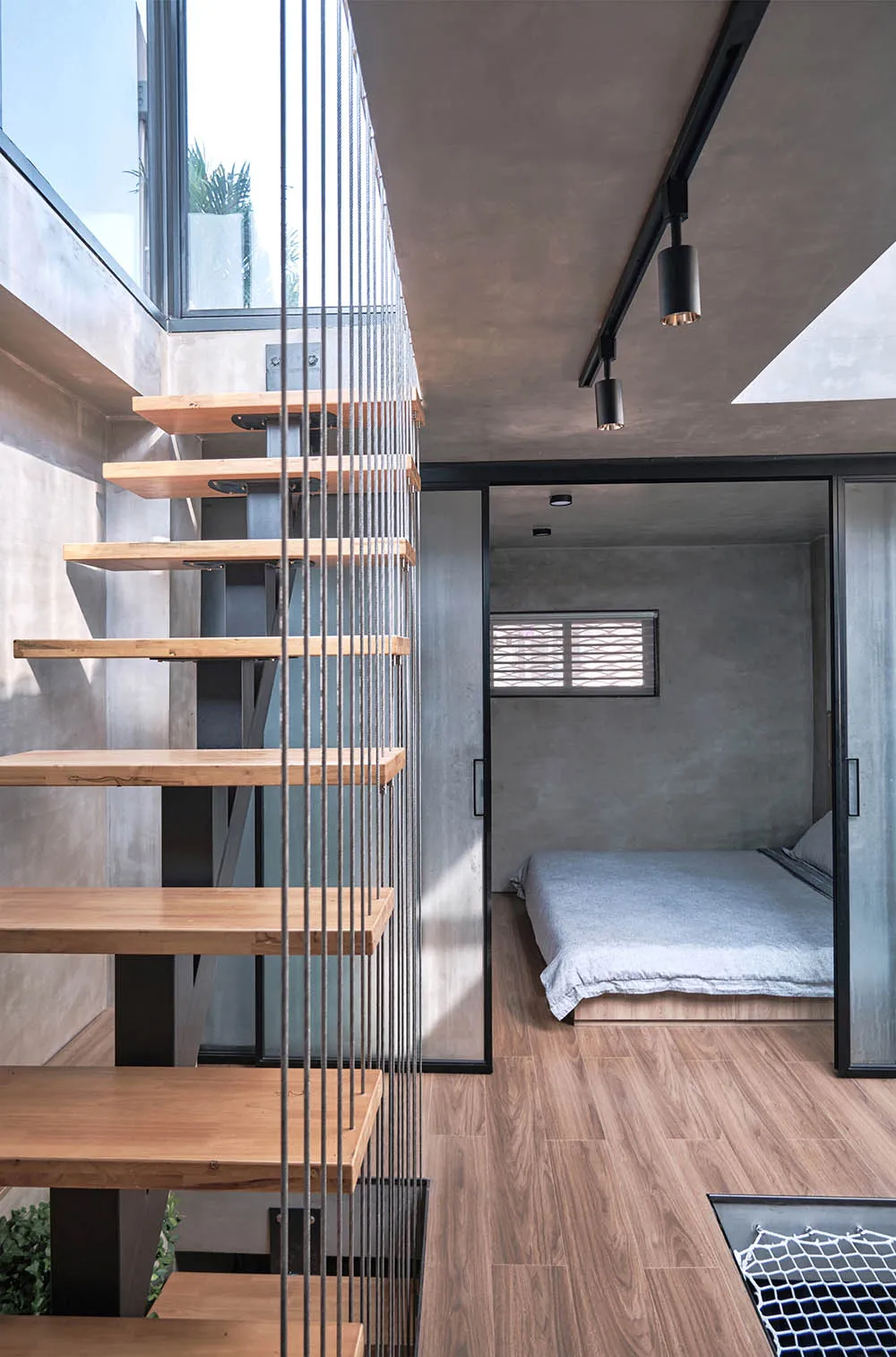Minimalist bathroom with concrete walls, wood furniture, and skylight.