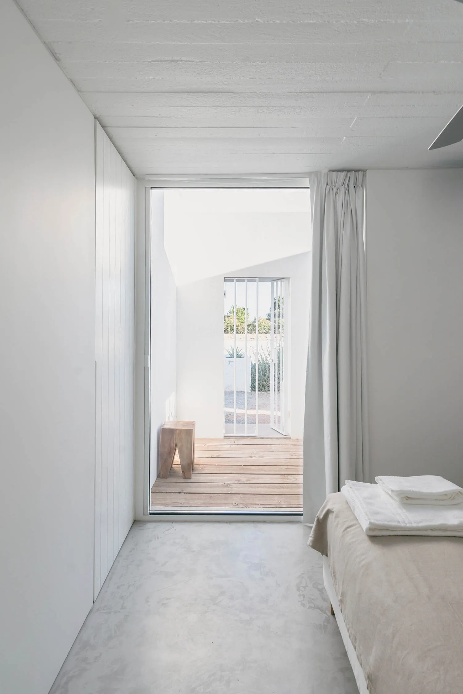 Minimalist bedroom featuring concrete and wooden elements