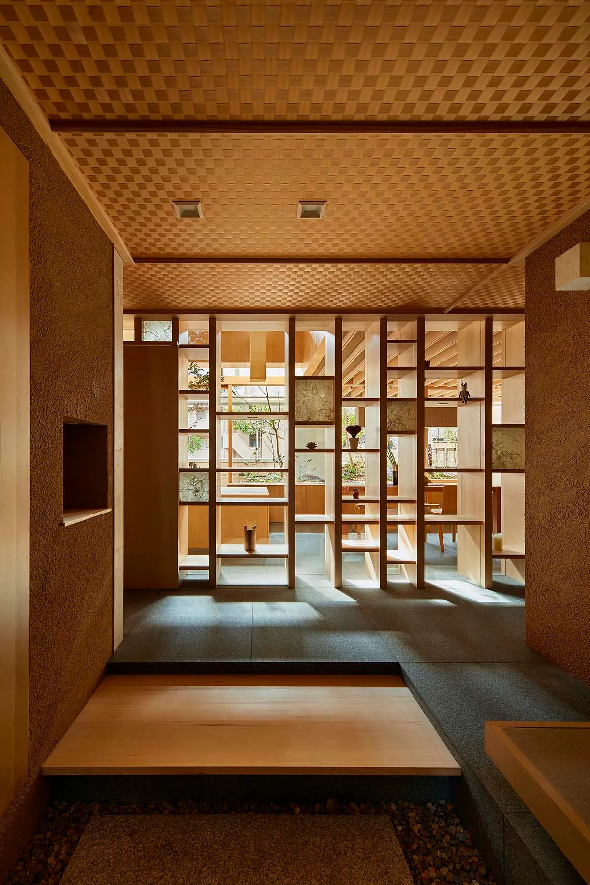 A minimalist interior featuring wooden elements and a sunlit space with shelves and decorations.