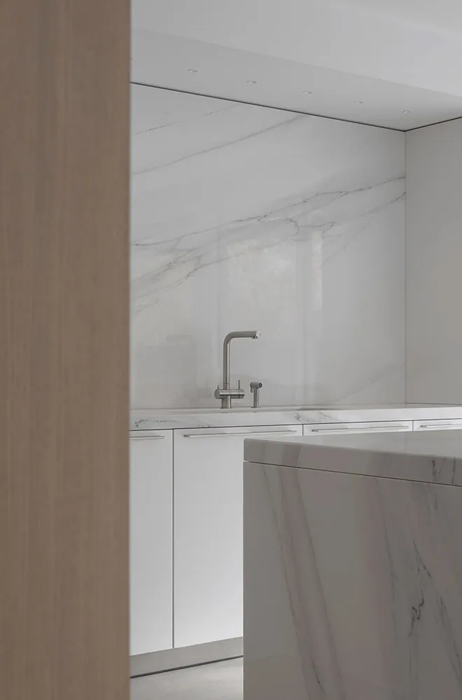 Modern kitchen with a marble backsplash and countertop.