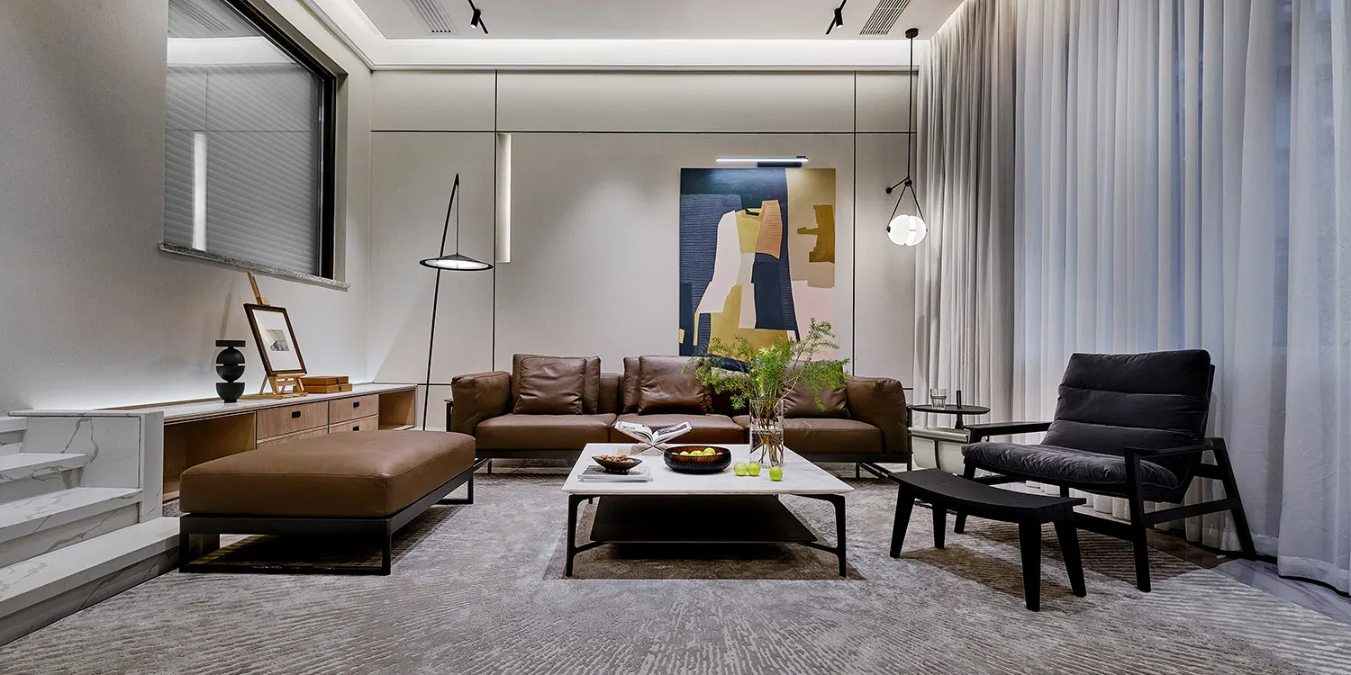 Modern living room with a leather sofa, marble coffee table, and glass pendant lights.