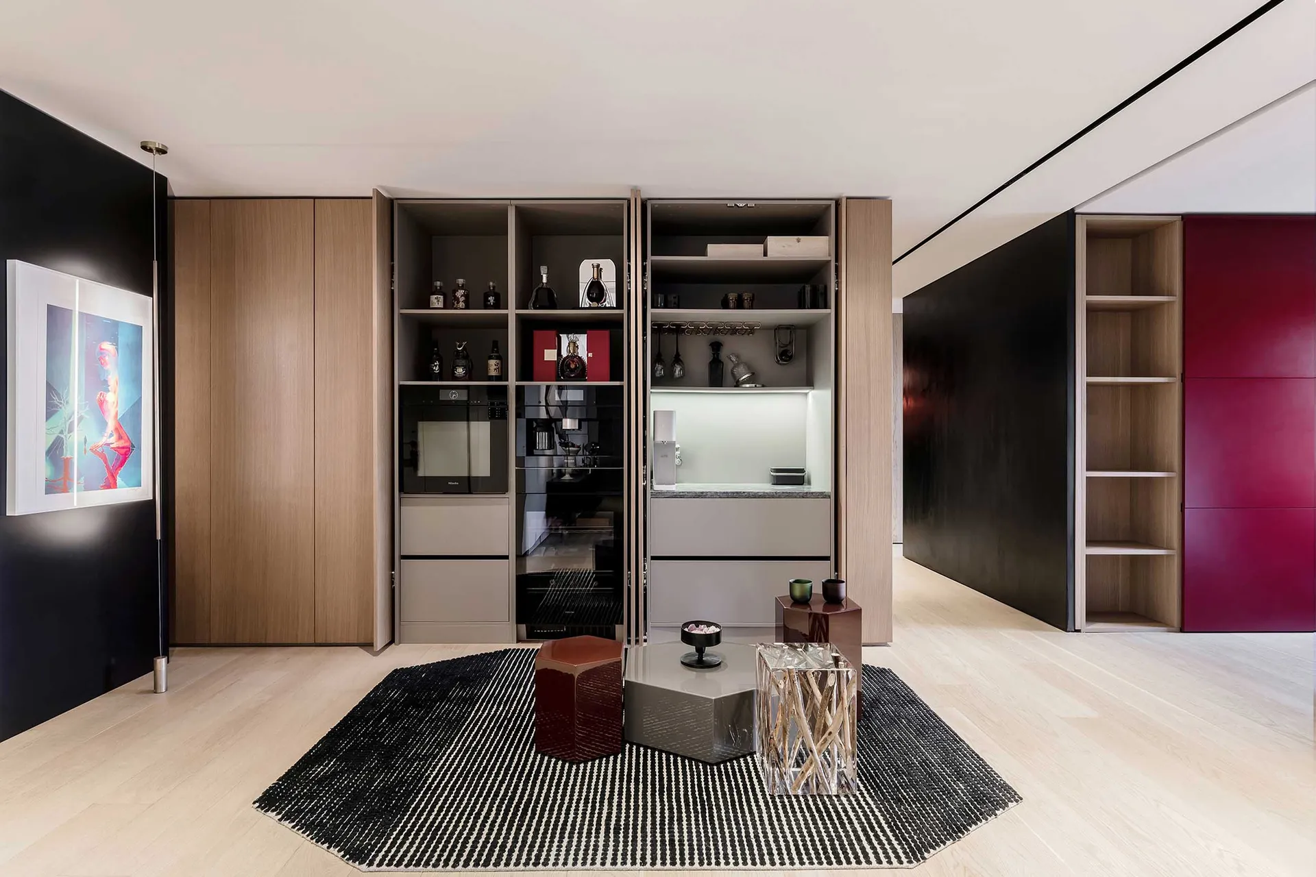 A modern kitchen featuring brown wood cabinets, shelves with bottles, and a coffee machine, illuminated by overhead lighting.