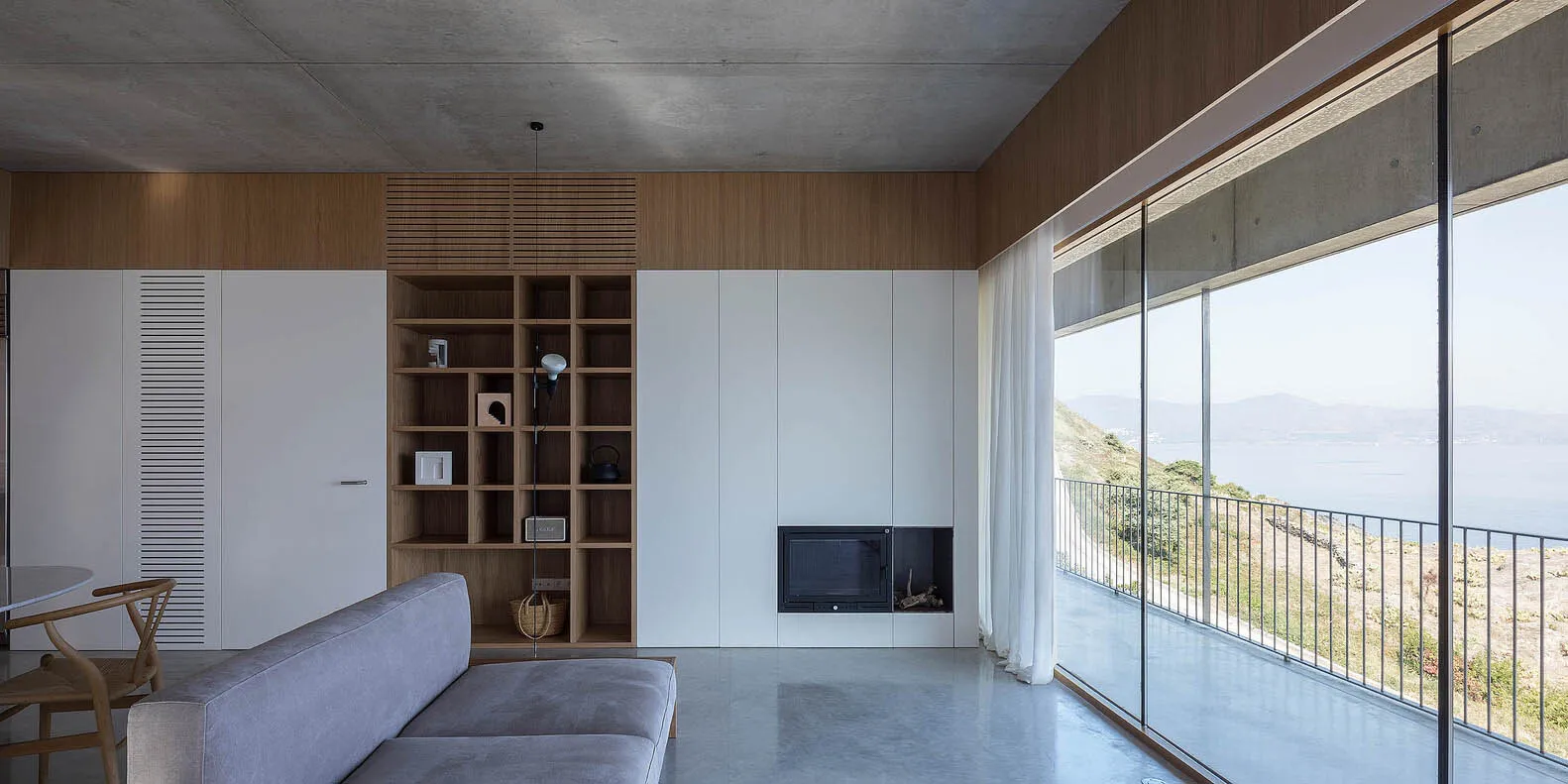 Modern living room with concrete floor and view of mountains.