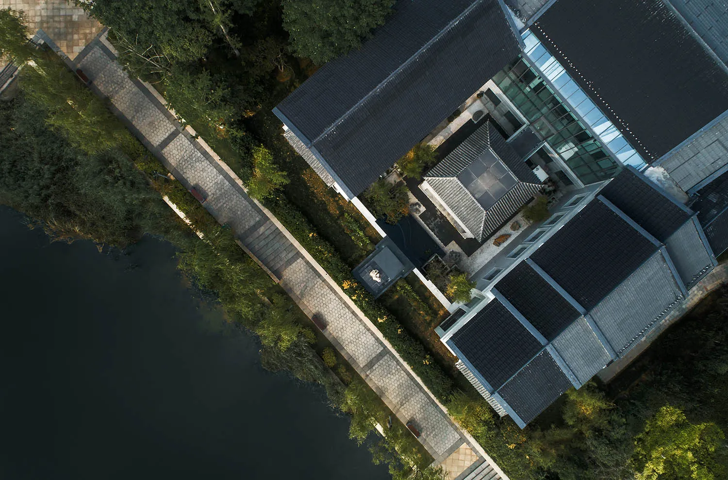 Aerial view of modern residential architecture featuring glass, concrete, and wood materials.