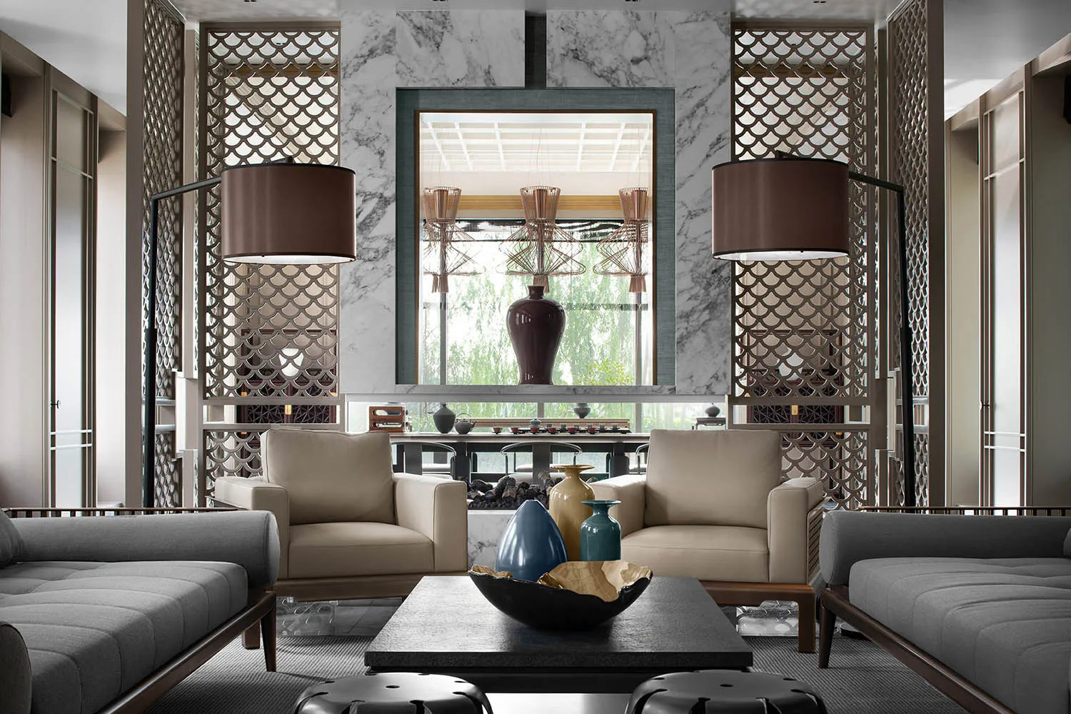 Modern living room with marble fireplace, leather chairs, and glass vases.