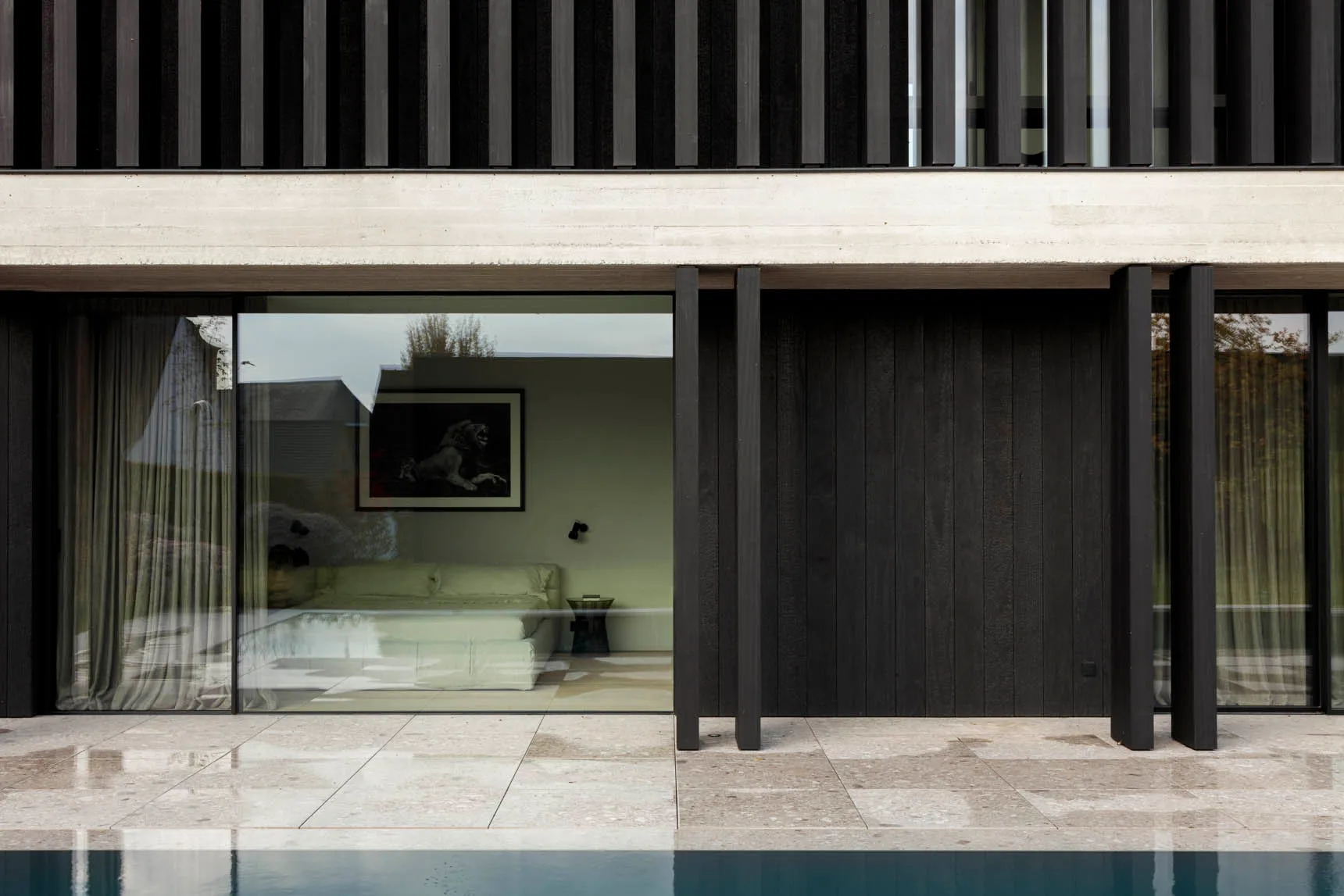 Modern outdoor living space featuring a sleek, contemporary pool deck constructed from concrete materials.