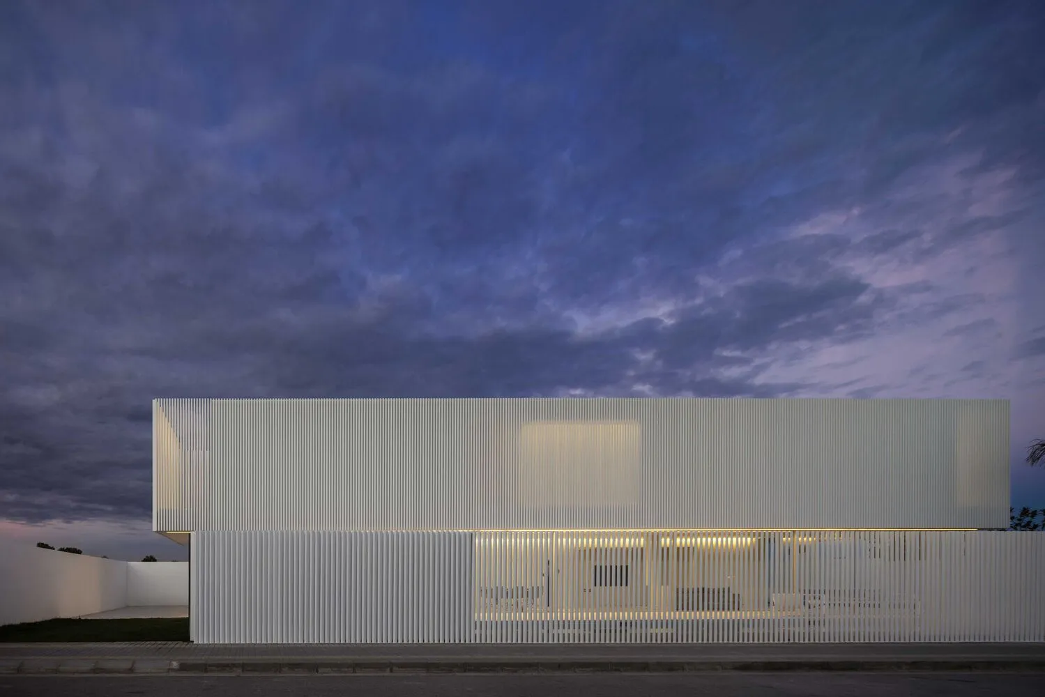 A modern building featuring metallic slats on its facade and exterior.