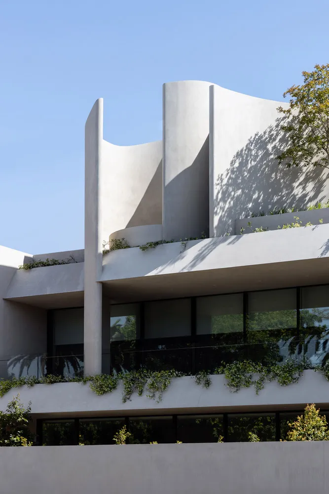 A modern building with curved concrete walls and large windows.