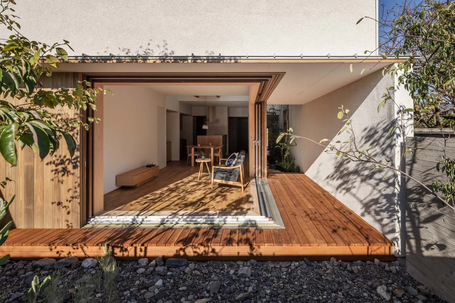 Modern exterior of a house with wooden panels and a wooden deck.