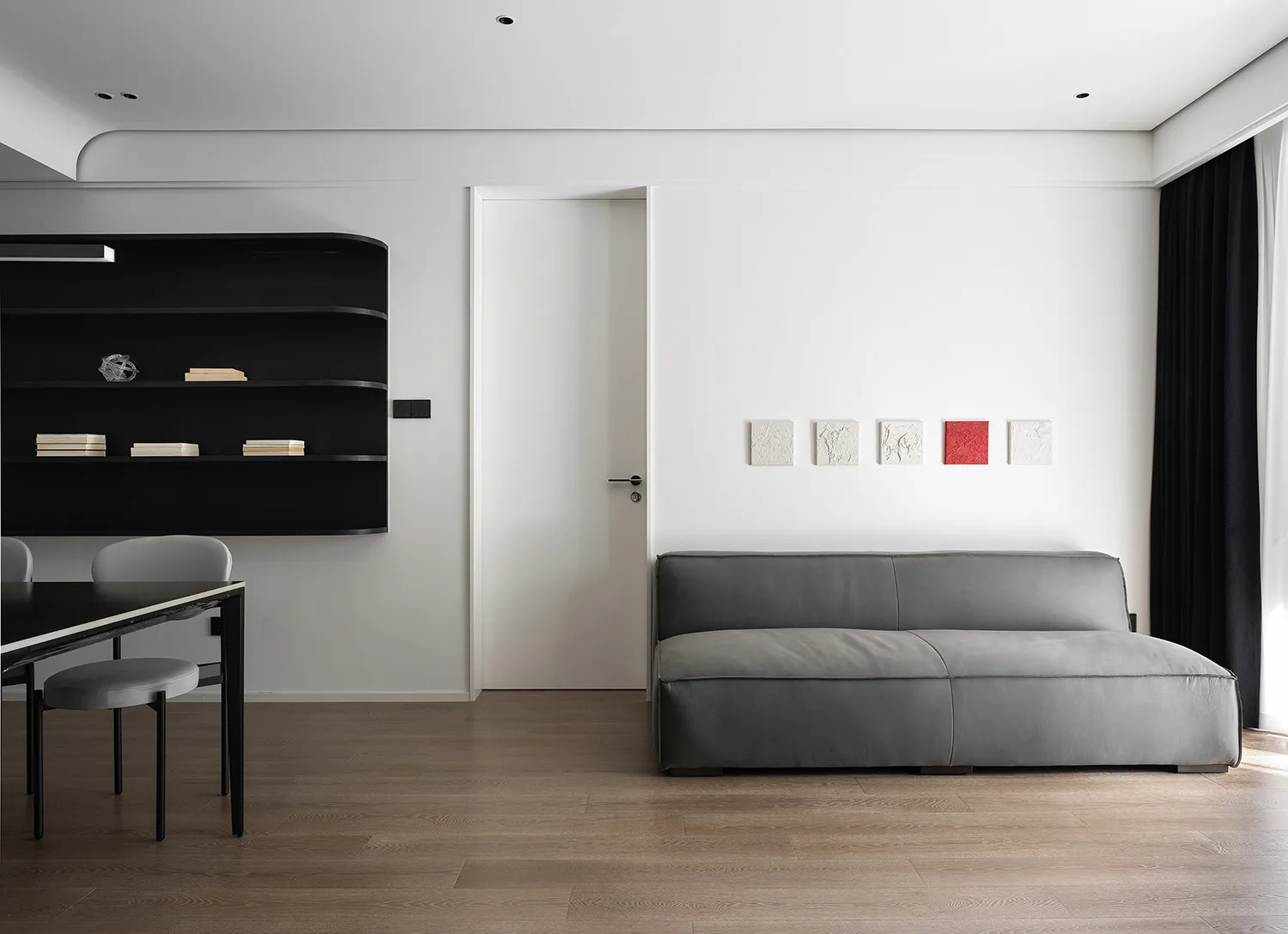 Modern living room featuring sleek leather furniture, wooden flooring, and glass accents.