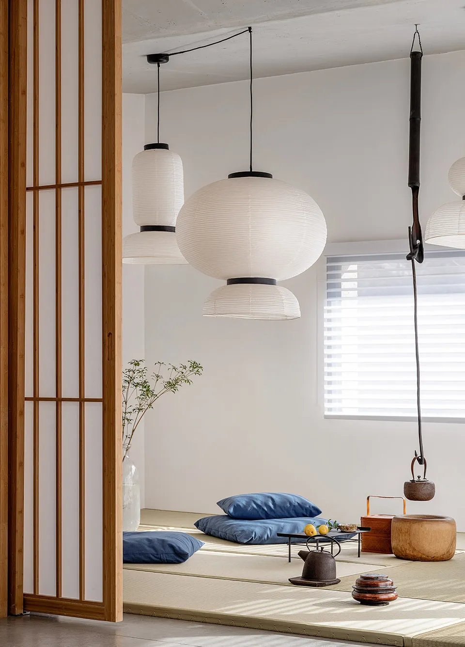 A minimalist living room with paper lantern lights and wooden furniture.