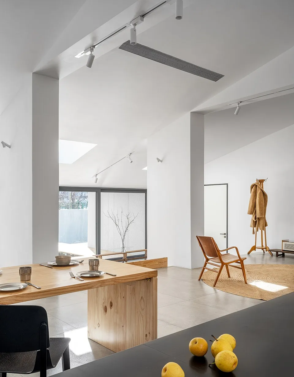 A minimalistic living room with a wooden floor and minimalist furniture.