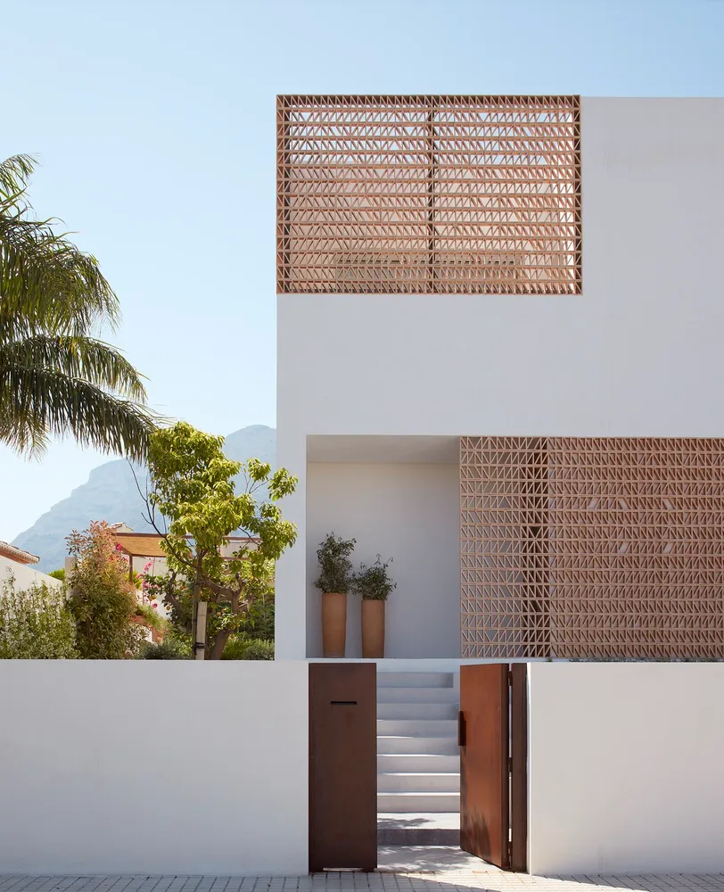 Modern minimalist residential house with concrete exterior and wooden elements.
