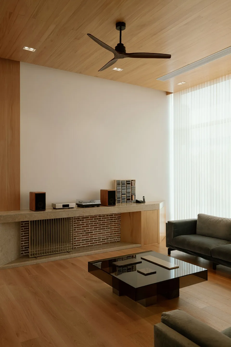 Minimalist modern living room featuring wood and brick materials