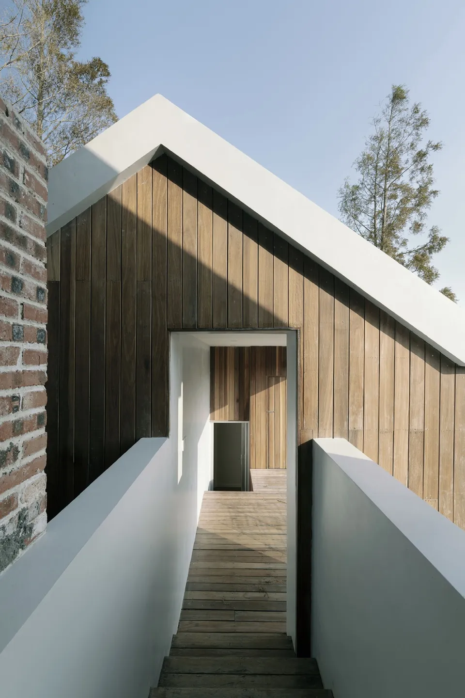 A wooden house exterior photographed outdoors with a clear blue sky.