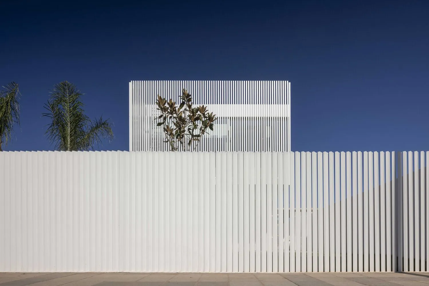 Modern building exterior with metal slats and white walls.