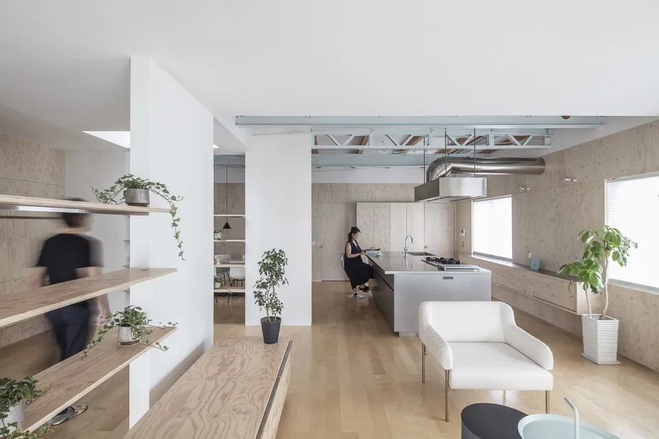 A minimalist residential kitchen with wooden surfaces and modern design elements.