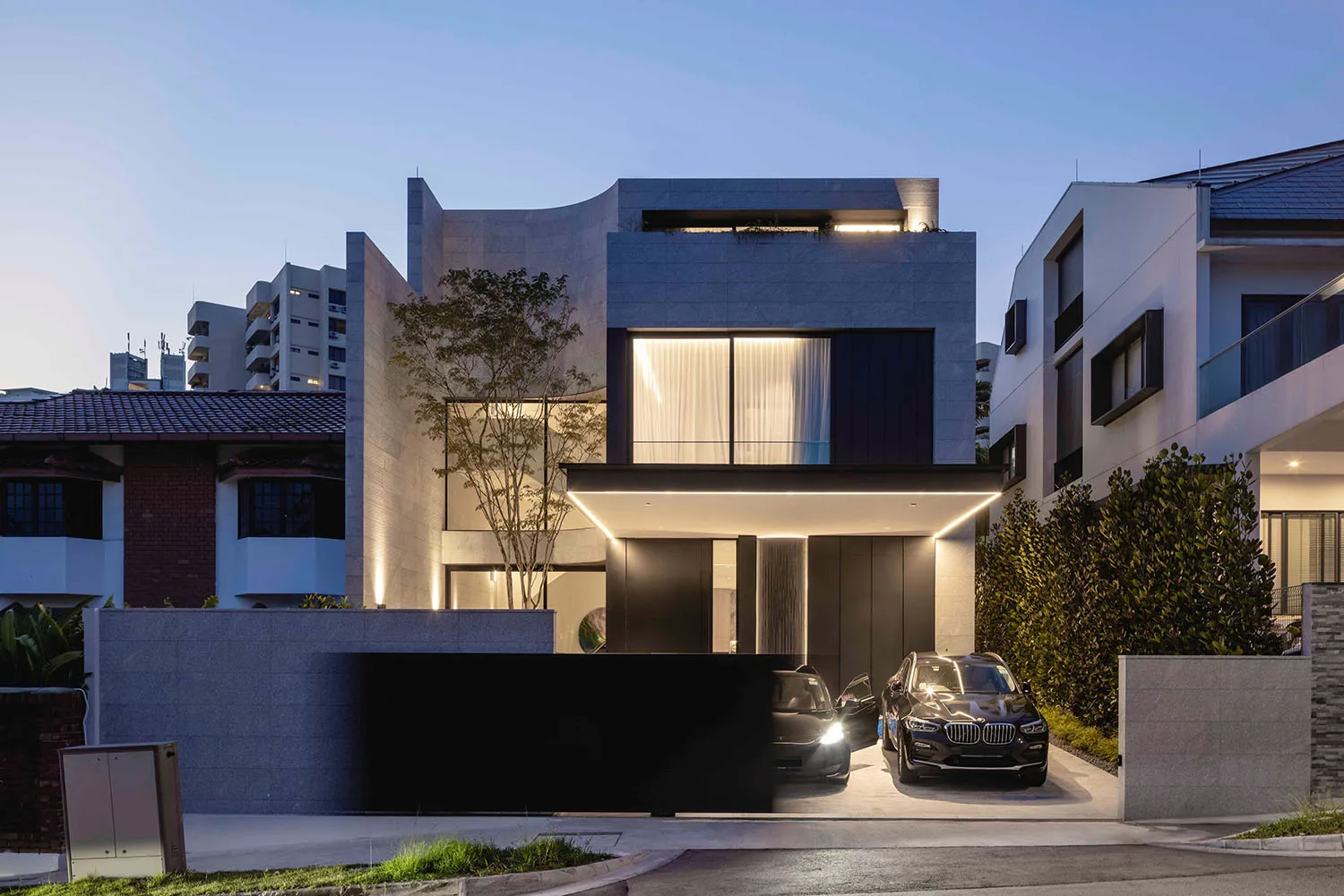 Modern residential building with concrete exterior and illuminated windows.