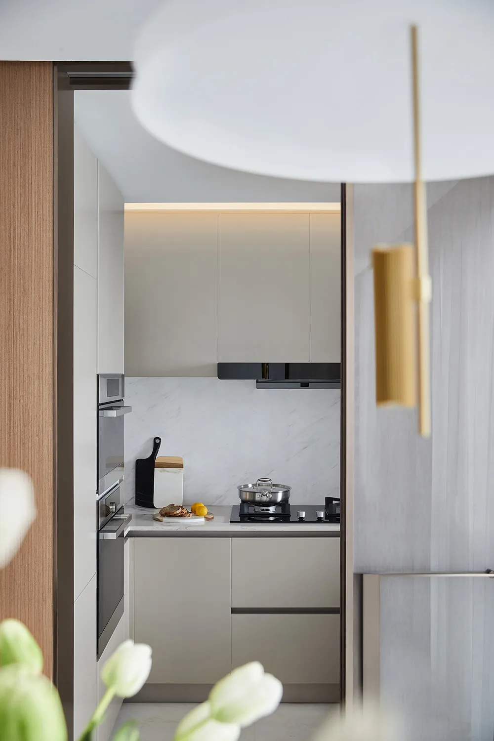 A minimalist kitchen with marble countertops and cabinets.
