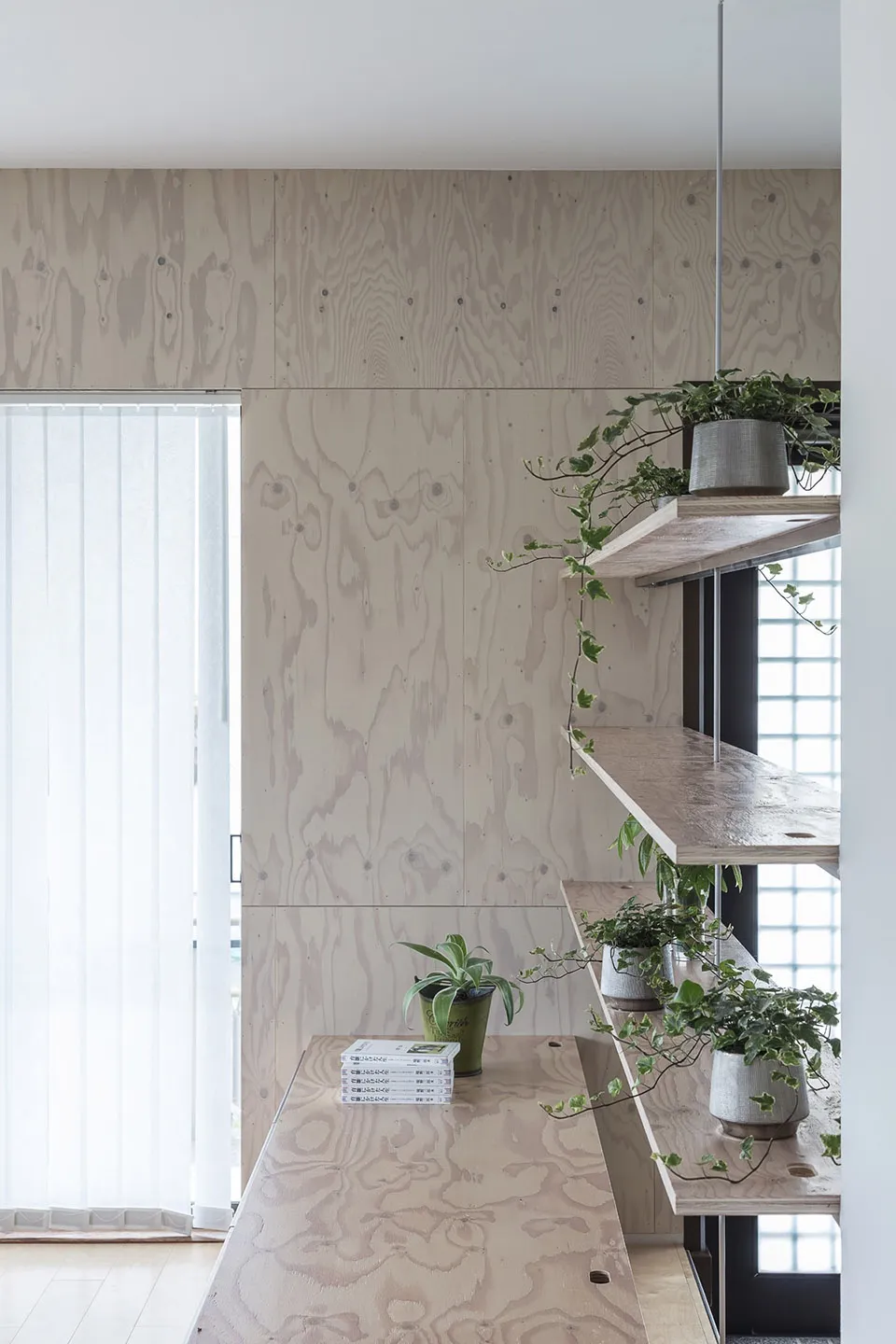 A minimalist home office with wooden paneling and indoor plants.