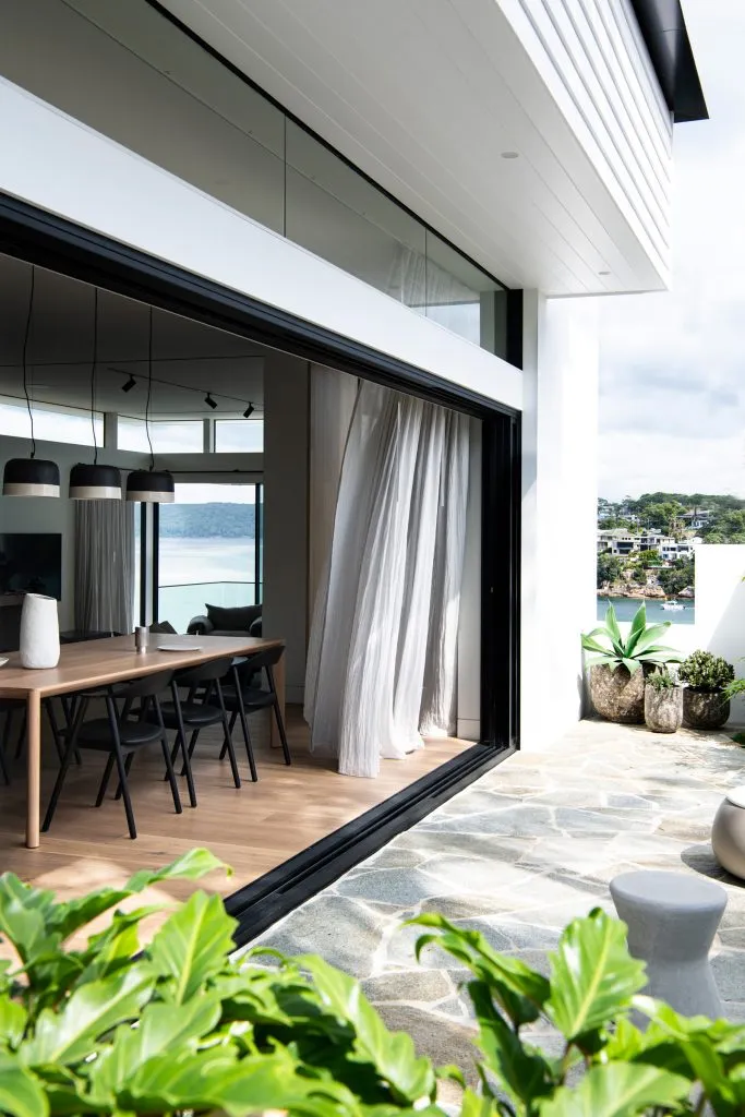 Modern residential interior featuring glass walls and stone flooring