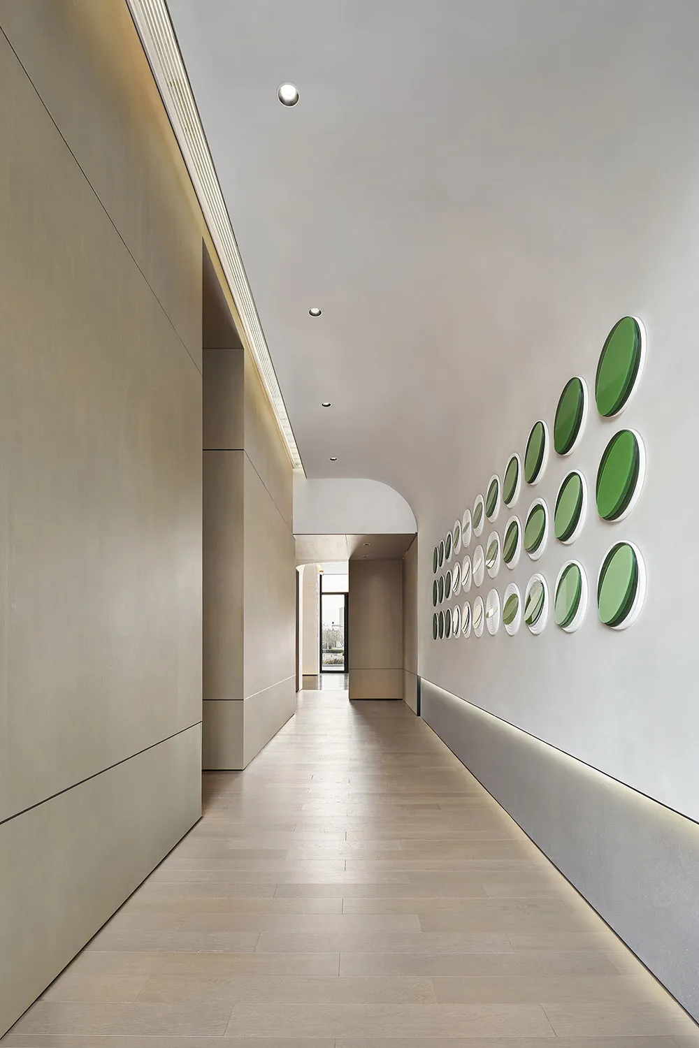A modern minimalist corridor with wooden walls and green circular decorations on the right wall.