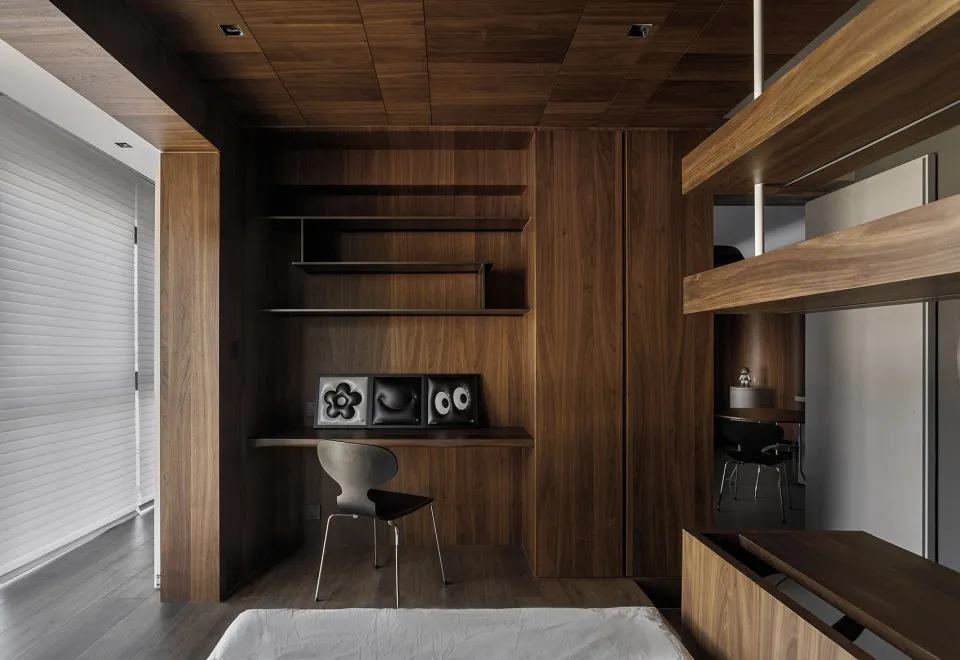 A minimalist home office with wooden shelves and a sleek workspace.
