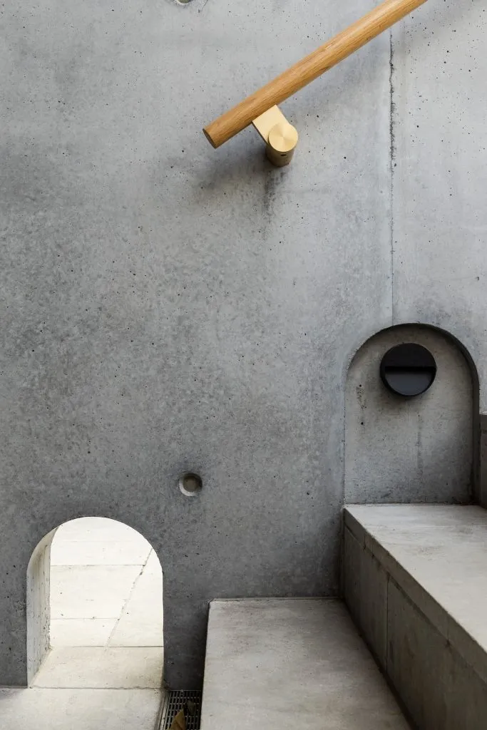 A minimalist radio room with a concrete wall and a circular window.