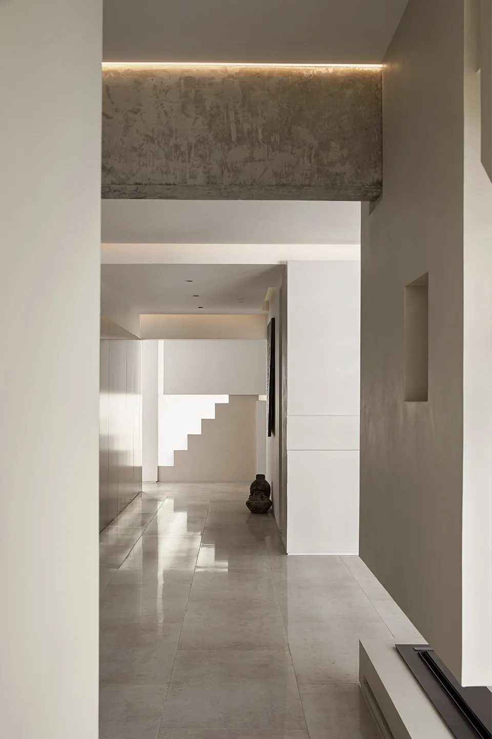 A modern entryway with a concrete tiled floor, large window, and minimalistic design.