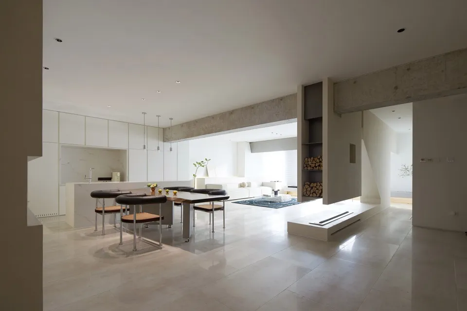 Modern, open-plan living and kitchen area with marble and concrete finishes.