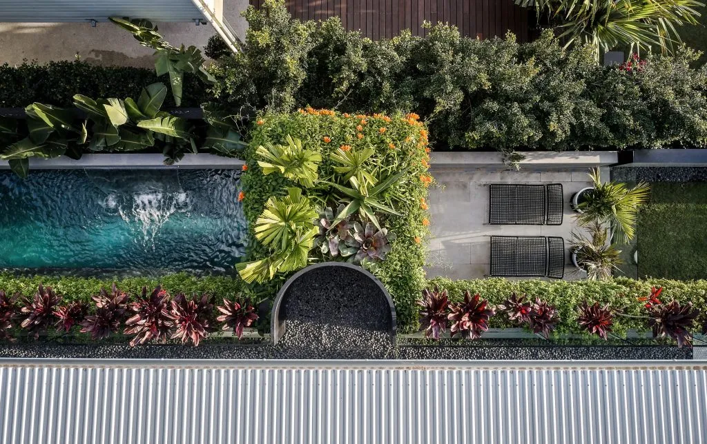 Aerial view of a modern patio featuring greenery, tile, and furniture.