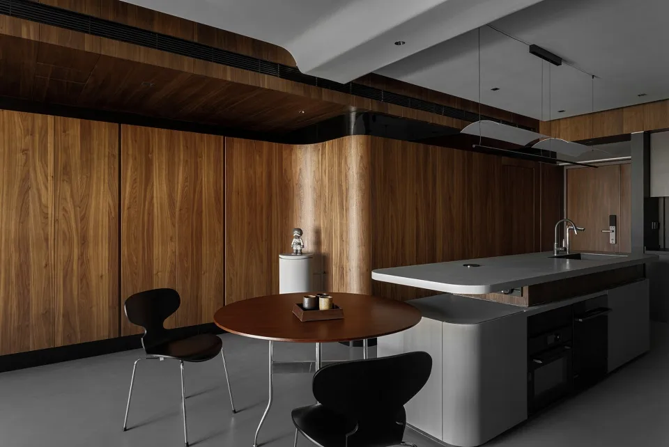 A modern residential kitchen featuring wooden cabinets and a concrete countertop.